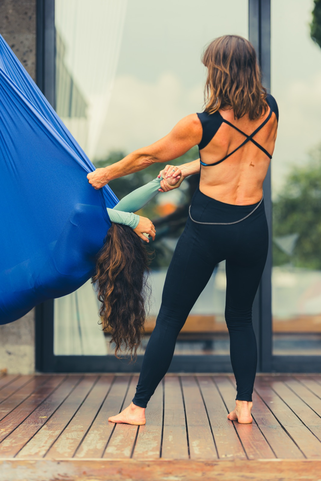 A practitioner cradling a client's head as they rest suspended in the swing