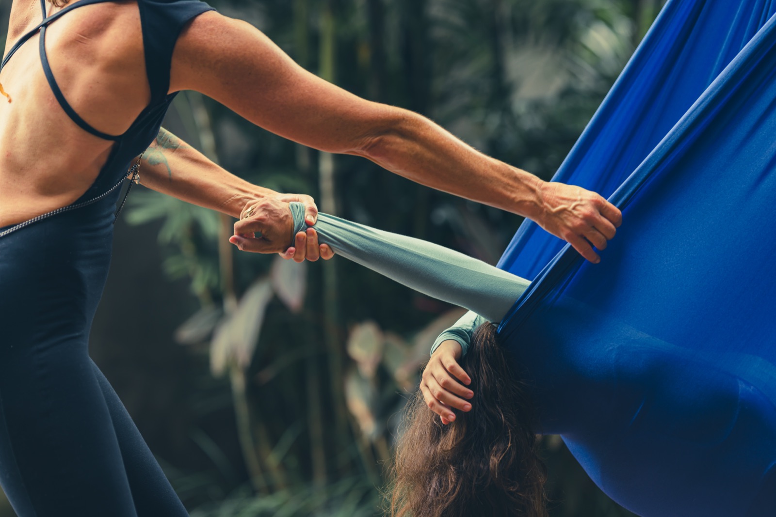 A close-up of hands adjusting the fabric of the swing around a client